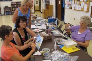 Dawn Feldhaus/Post-Record
Jan Wyninger shows her most recent painting to instructor Nancy Ryan and Barbara McHenry, as Dolly Jendro works on her own artwork at the Washougal Community Center. The Washougal Watercolorists will host an opening reception Friday, from 5 to 8 p.m. "The purpose of the show is to share with the community the joy of watercolor and to complete the process of creation," Ryan said. "Part of creation is having others appreciate and enjoy it."