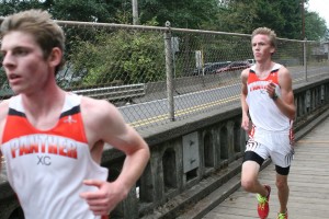 Washougal seniors Sean Eustis (left) and Isaac Stinchfield sprint to the finish line Thursday, at Round Lake in Camas. Eustis won the race with a time of 17:22 and Stinchfield took second in 17:23.