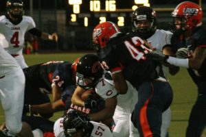 Camas High School offensive linemen Drew Clarkson, Troy Patterson and Jason Vailea part the waters, and Nate Beasley dives into the end zone to score the first of his four touchdowns for Papermakers. Camas smashed Lakes 53-14 Friday, at Harry Lang Stadium in Lakewood.