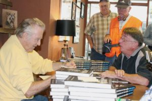 Singer, song writer and author Jimmie Rodgers (left) chats with Camas resident Barry Lutz (right) as others wait in line during a book signing event Saturday afternoon for Rodgers' autobiography "Dancing on the Moon." Rodgers, a Camas native, also performed two concerts at Journey Community Church on Sunday. Lutz had Rodgers sign an old 45 rpm vinyl record version of Rodgers' song "I Always Knew," produced by Zig Zag Records.