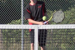 Gus Cooper lobs the tennis ball over the net for Camas Wednesday.