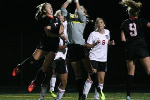 Anyssa DeVera, Perri Belzer and Maddy Belzer watch Camas goalkeeper Lauren Rood punch the soccer ball away from the Union Titans Thursday, at Doc Harris Stadium.