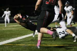 Camas quarterback Liam Fitzgerald leans back and stretches his arm across the goal line to score the first of six touchdowns Friday, at Doc Harris Stadium.