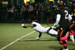 Bryan Kelly lunges across the goal line to score the second of his three touchdowns for Camas Thursday, at District Stadium.