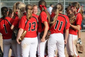 The Camas slowpitch softball players give a rally cry before scoring five runs in the top of the seventh inning of the district championship game Monday, at Heritage High School.