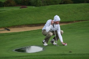 Brian Humphreys places his golf ball on the 18th green Oct. 8, at Tri-Mountain. After a lightning delay, the Camas High School sophomore putted the ball in for the 4A district championship.