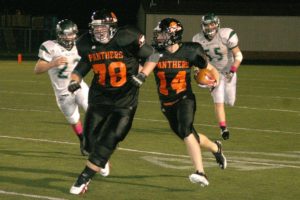 Washougal sophomore Christian Edmonson (78) opens a lane to the end zone for senior Caleb Howard (14) Friday, at Fishback Stadium. The Panthers had a 14-point lead at halftime, before the Woodland Beavers rallied for a 35-28 victory in double overtime.