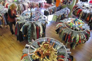 Robin Simonds, manager of Lil' Dudes and Divas, arranges racks of "gently used" children's outfits in the downtown Camas shop. New clothing and accessories are displayed along the walls. Toys, games and baby strollers are also available, and there are handcrafted items made by area crafters. Art classes for toddlers will be offered, starting in November. The owner of the boutique and consignment shop, Erika Peterson, recently relocated the business from Vancouver.