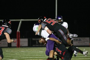 Camas High School seniors Matt Danis (56) and Jorden Payne (3) crumple the Heritage receiver Friday, at Doc Harris Stadium.