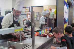 Washougal Mayor Sean Guard serves lunch to children at Gause Elementary School in celebration of National School Lunch Week.