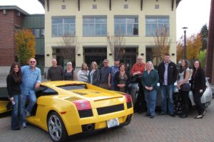 Terry Williams (second from left), president, chief executive officer and founder of Transport Holding Co., Inc., stands with his fiance Felicia Bond and staff members, by his 2004 Lamborghini, in Reflection Plaza. Bond is the Texas regional director for Red Carpet Auto Transport, Inc., one of the six auto shipping brokerages that Transport Holding owns. Williams recently moved his company's offices from downtown Camas to Washougal Town Square.