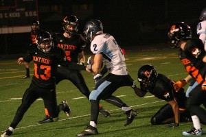 Donald Holbert clings to a Hockinson Hawk before Brandon Casteel and Luke Hiersche join the fray Friday, at Fishback Stadium. The Hawks defeated Washougal 27-14 to force a three-way playoff between these two teams and Aberdeen today, at Kelso High School.