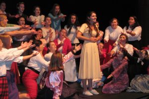 Sandy (Liza Hess ) sings of her summer with Danny while the girls demand more information. The WHS production of "Grease" will include a sock hop before each performance, where the audience can be on stage and dance with the cast.