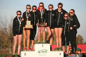 The Camas High School girls cross country team stands on the podium as 4A state champions Saturday, at the Sun Willows Golf Course, in Pasco.