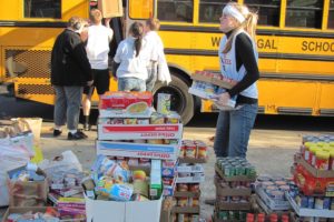 Students fill a school bus with non-perishable food items during last year's Stuff the Bus food drive, which generated 61,000 pounds of food. Organized by the Camas-Washougal Business Alliance, the effort is a friendly competition between Camas and Washougal high schools and involves students in all grade levels.