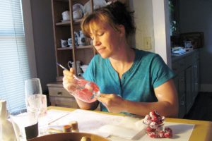 Alison Jurgens-Meyer paints images of mums onto a wineglass at her home in Camas. She can also paint vases, plates and coffee cups, as well as champagne flutes and beer glasses, for occasions such as birthdays and anniversaries.