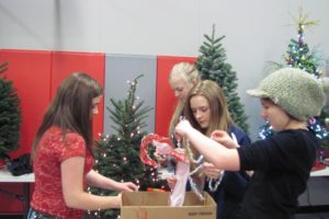 Canyon Creek Middle School ASB representatives (clockwise, from left) Natalie Garner, Bridgette McCarthy, Danielle Smyth and Jeannine Jones decorate a tree in school colors of silver and red. It is the third year Canyon Creek ASB has participated.