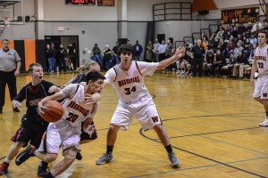 Washougal's Austin Tran rolls by Camas defenders Trent Johnson and Drew Clarkson on a pick set by Aaron Deister. The Panthers defeated the Papermakers 59-48 Friday, at Washougal High School.