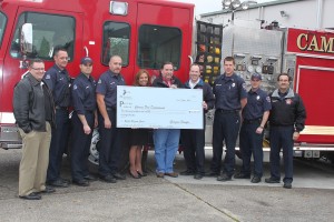 Georgia-Pacific officials presented a check for $10,000 to the Camas Fire Department. Pictured above are (left to right) Mayor Scott Higgins; CFD employees Kevin Villines, Wade Faircloth, Chris Richardson; Camas Mill Spokeswoman Nancy Viuhkola, Camas Plant Manager Gary Kaiser; and CFD employees Cliff Free, Kevin Bergstrom, James Tierney and Larry Larimer.