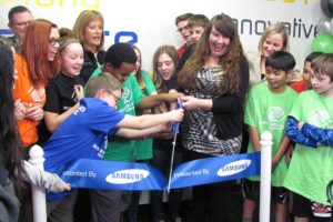 Amber Barnes, unit director for the Jack, Will and Rob Boys & Girls Club, is assisted by club members during the  ribbon cutting ceremony for the new Tween Tech Center on Tuesday.