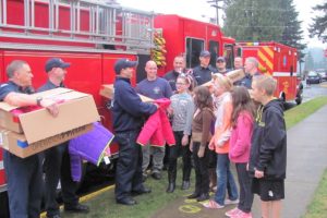 Hathaway Elementary School student body officers accept a donation of 36 coats from the East Clark Professional Firefighters Local 2444 for fellow students in need.