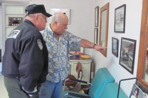 Retiring Clark County Sheriff Garry Lucas (left) recently looked at historical photos of downtown Camas, with Lyle Shaver (right), former owner of Sportsman Barber Shop. That business is located at 214 N.E. Fourth Ave., next to the former site of Cowan's Cigar Store, a tavern restaurant that was owned by Lucas' father, Donald Lucas, and uncle, Lamont "Smokey" Lucas, from the mid-1940s to the early 1950s.