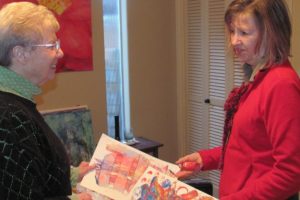 Fellow artists and friends Katey Sandy (left) and Judith Howard reminisce about a children's art project they collaborated on prior to retirement. The two will host an art show, which opens Friday at the Second Story Gallery.