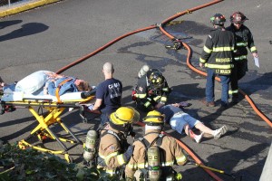 An emergency situation that involved an explosion in the maintenance basement at the Port of Camas-Washougal offices was staged as part of a drill on Tuesday, April 23. Above, volunteer "victims" John Wagoner and Karina Hankin are tended to by paramedics and firefighters from the Camas-Washougal Fire Department.