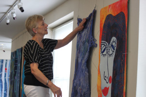 Second Story Gallery Society Board of Governors member Ulrike Halverson works meticulously to hang the fiber art pieces that are part of this month's show at the Second Story Gallery at the Camas Public Library. Also part of the effort were Tulla Burke, Mary Alice Pfeifer and Joel Emanuel. "We have a lot of fun," Halverson said.