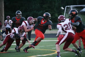 DeAundre Summers carries the football and a Stevenson Bulldog for a couple yards Friday, at Fishback Stadium. Washougal shut out Stevenson 29-0.