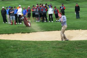 An anxious crowd watches Brian Humphreys blast the ball out of the sand during a playoff to determine the winner of the Jeff Hudson Invitational Sept. 15, at the Tri-Mountain Golf Course in Ridgefield. Humphreys, of Camas High School, and Ben Gruher, of Union, both shot 4-under par to tie for the lead. Gruher beat Humphreys by two strokes on this hole to claim first place.