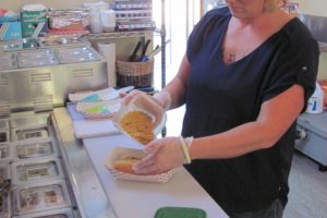 Ashley Brown, a beer tender at River Dogs & Growlers, prepares a "Left Coast Coney" hot dog with chili, yellow mustard, chopped onion and Frito crumbles. The new bar, in downtown Washougal, serves customers 21 and older. Beer, wine, hard ciders and soda are available to purchase. There are three flat-screen TVs, with access to the NFL, NBA, MLB and NHL networks. "We have music and sports," Brown said. "Itís very relaxed, with games and books."   