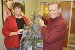 Charline Wright of Columbia River Realty and Festival of Trees Chairman Chuck Carpenter create the grand prize tree boosting 100 lottery tickets. The tree will be raffled to selected bidders from each of the decorated trees. (Contributed photo)