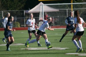 Perri Belzer moves the soccer ball up the field with encouragement from her Camas teammates Saturday, at Sparks Stadium in Puyallup. The Papermakers beat Gonzaga Prep 2-0 for third place at state.