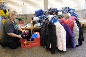 Shantelle Arney organizes donations made to Washougal Family Dental. The coats, gloves, hats and blankets will be given to local homeless people.            