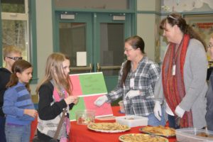 Cape Horn-Skye Elementary School students Sarah Vandehey and Mercedes Green are served cookies by Mary Ellen Grode and Andi Crockford. The two women, along with five others, baked several dozen cookies for the students to show them that, "people still care and they are loved." Photo by Rene Carroll