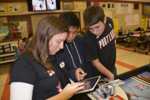 Instructor Cherise Marshall works with team members Sean Marcos and Sean Seifert during a class at JMS.