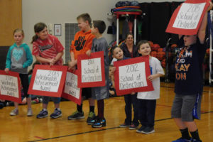 Cape Horn-Skye students hold up signs representing the number of times the school has been named a statewide School of Distinction during an assembly last week. 