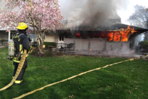 Firefighters battle a blaze that broke out this morning at 4108 N.W. McIntosh Road, in Camas. Initial efforts to put the fire out were challenged by the fact that there was no nearby fire hydrant. A 1,500-foot hose was needed to transport water to the scene. Photo courtesy of the Camas-Washougal Fire Department.