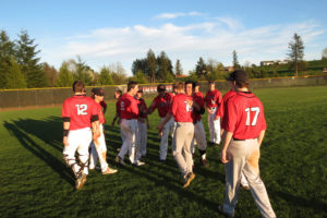 The Camas High School baseball players celebrate with Taylor Adams (15) after the sophomore drove in the tying run and scored the winning run against Union Wednesday. The Papermakers also defeated the Titans 2-1 the day before. 