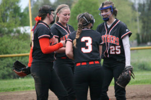 Washougal infielders Kayla Lagerquist, Courtney Shelly and Morgan Ratcliff congratulate Paige Forsberg (25). She picked up the win in relief over Ridgefield Wednesday and then held Woodland to one hit Friday.