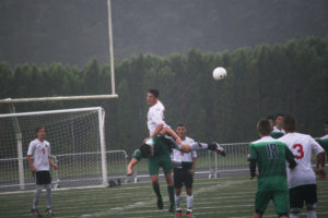 Danny Wing rises above a Falcon and heads the soccer ball back in Camas' direction Saturday, at Doc Harris Stadium.