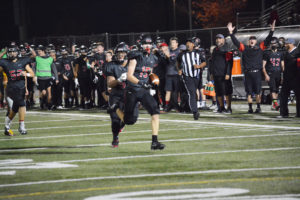 The Camas sideline goes crazy as Cooper McNatt runs free Friday, at Doc Harris Stadium. The Papermakers smashed Enumclaw 56-0 in the first round of state.