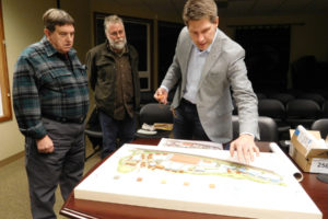 Larry Keister and Richard Hamby, both of Washougal, watch David Hansen set up a clay model of a draft waterfront master planning vision prior to the Dec. 14 Port of Camas-Washougal workshop. Lance Killian, president of Killian Pacific, has said development of the waterfront could create more than 500 jobs.