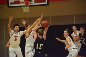 Camas High School seniors Bryan Nguyen, Cooper McNatt and Logan Miller defend the paint against Glacier Peak Dec. 21, in Camas. The Grizzlies beat the Papermakers 63-54. 