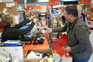 Rosie Lutz, an employee and former co-owner of Lutz Hardware in Camas, assists a customer with the purchase of a snow shovel. Sleds and ice melt have also been selling well, during the inclement weather. 