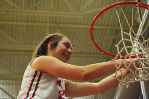 Teague Schroeder collects a piece of the net after the Camas High School girls basketball team beat Skyview 42-24 Feb. 1, to become league champions for the first time in the program's history. 