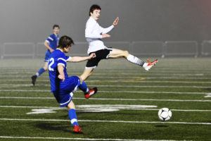 Brennan Smith glides to the soccer ball on a rainy and foggy night at Doc Harris Stadium Monday. The CHS senior scored the tiebreaking goal in the 62nd minute that helped the Papermakers defeat Ridgefield 2-1. (Photo courtesy of Kris Cavin)