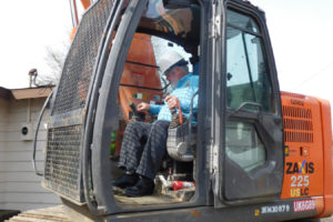 Washougal Mayor Sean Guard prepares to use an excavator to begin the demolition process of the Camas-Washougal Salvation Army office. Five modular units will be added to the ministry's local site. 