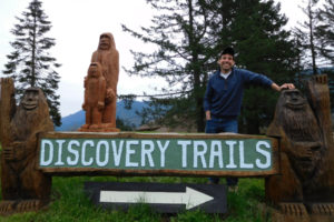 Jacob Meyer, Executive Director of the Bonneville Trails Foundation, stands by the Bigfoots that welcome families to Discovery Trails at milepost 38 on State Route 14. Meyer said this "under-utilized" area leads hikers through 12 miles of paved paths, where they will find 30 different Sasquatches along North Bonneville and the Columbia River. 